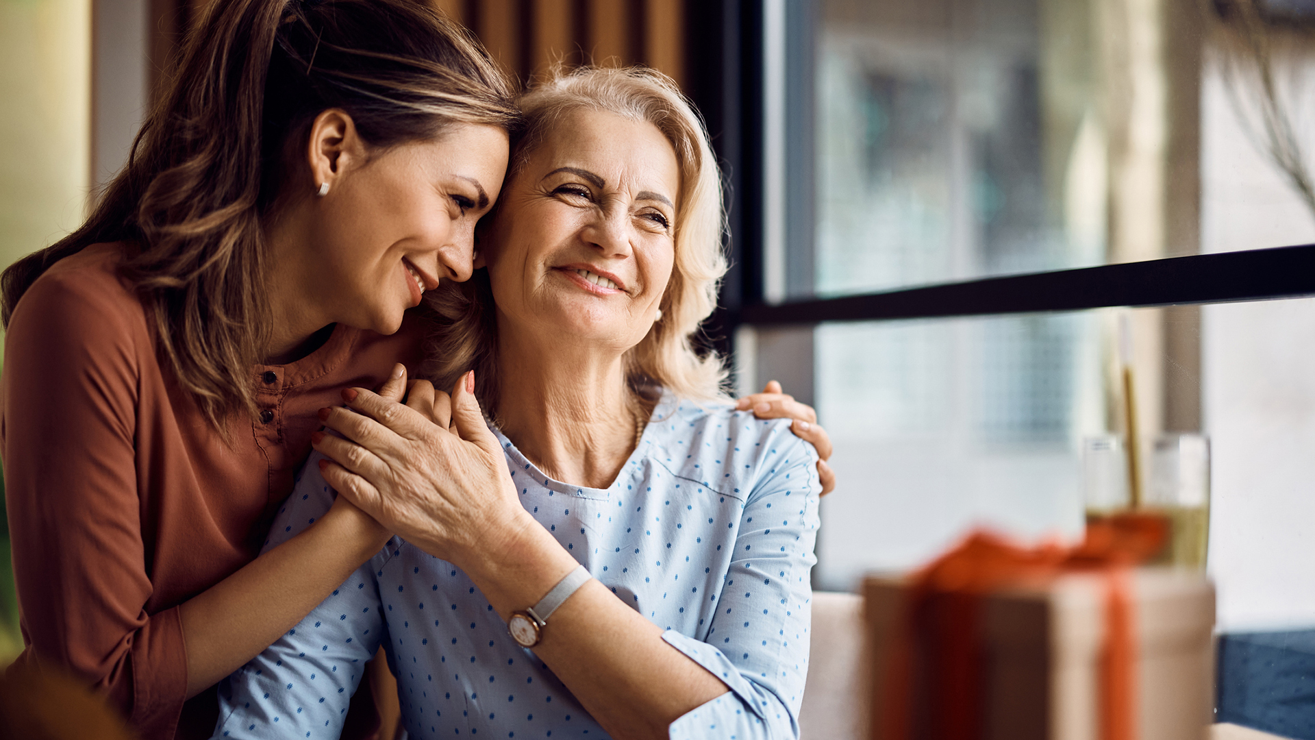 senior woman and adult daughter hugging