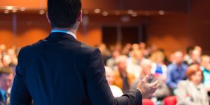 man presenting to an audience a ted talk on retirement and aging